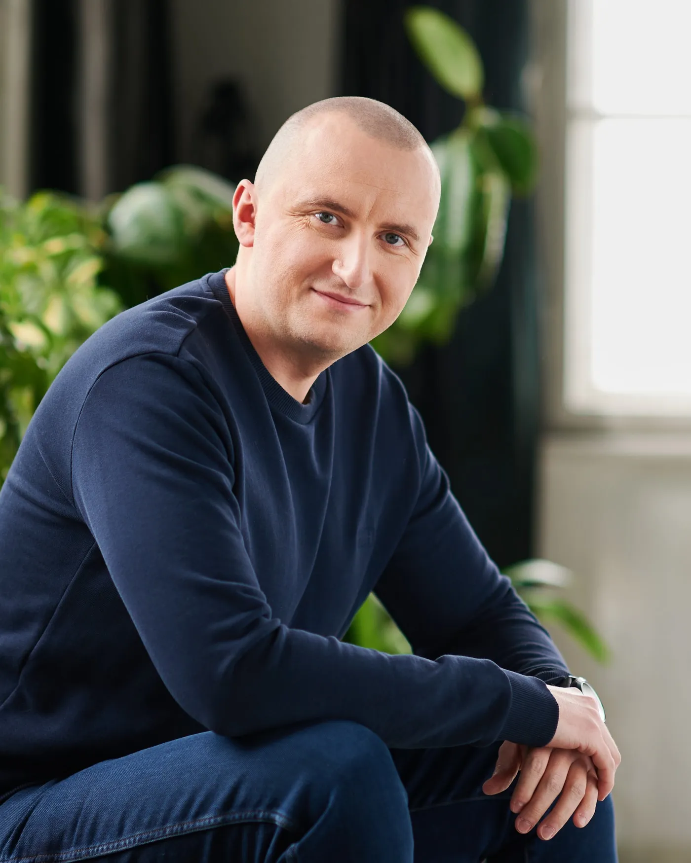 Łukasz Roszak siedzący w fotelu, patrzy w obiektyw